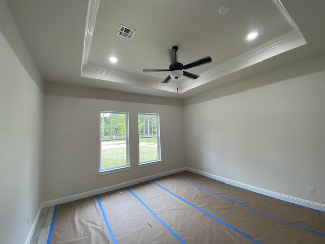 spare room featuring ceiling fan, a raised ceiling, and crown molding