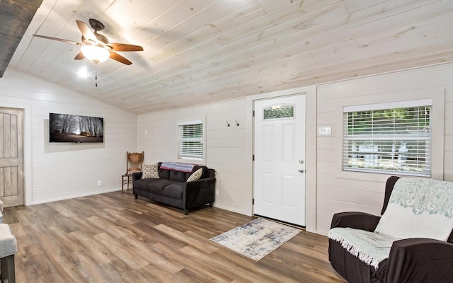 living room featuring hardwood / wood-style flooring, vaulted ceiling, wooden walls, and wood ceiling