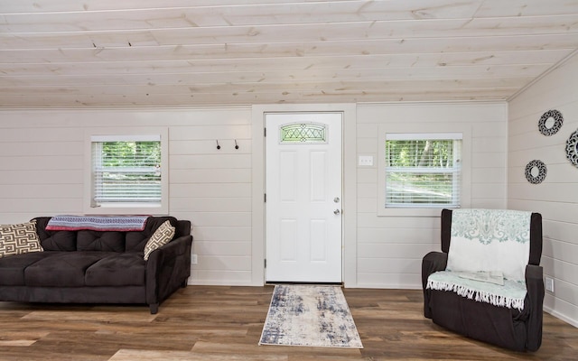 entrance foyer with lofted ceiling, dark wood-type flooring, and wooden walls