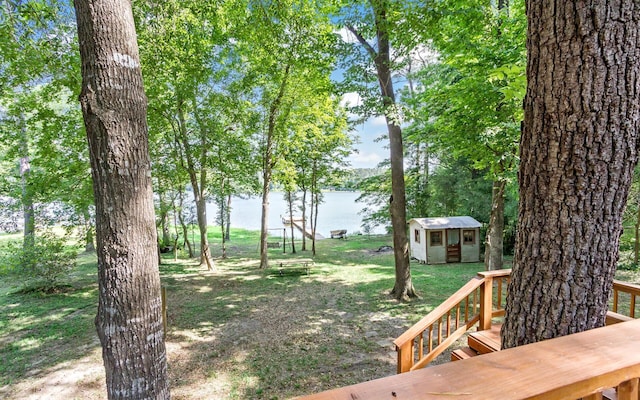 view of yard with a water view and a storage shed