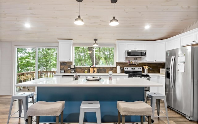 kitchen featuring pendant lighting, light wood-type flooring, stainless steel appliances, and wooden ceiling