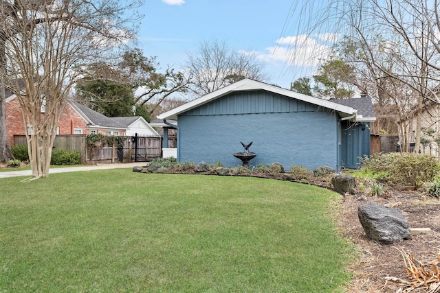 view of side of home with a yard, a chimney, and fence