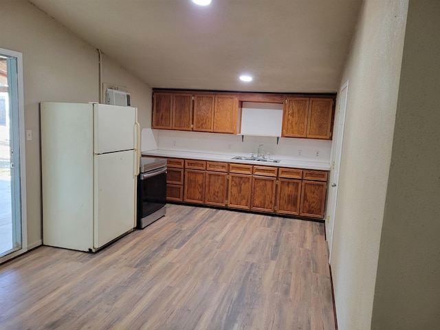 kitchen featuring range, white fridge, light hardwood / wood-style flooring, and sink