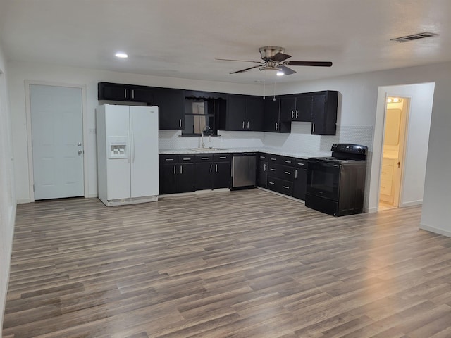 kitchen featuring sink, black electric range oven, stainless steel dishwasher, white refrigerator with ice dispenser, and backsplash