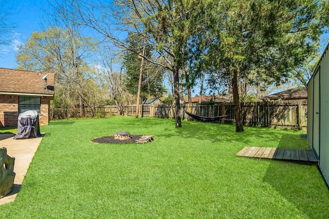 view of yard featuring a fire pit and a fenced backyard