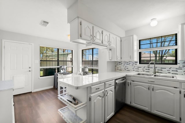 kitchen with visible vents, backsplash, dishwasher, a peninsula, and a sink