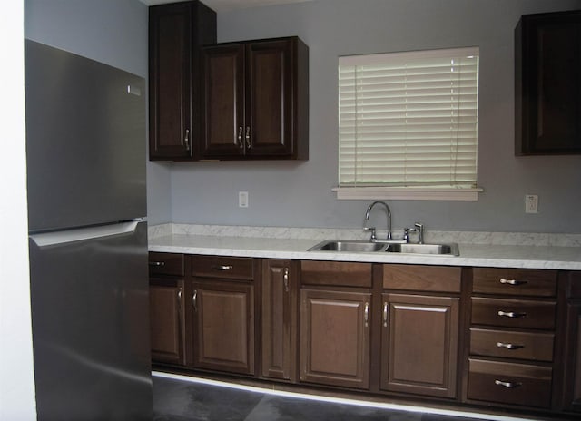 2716 22nd St, Port Arthur, TX 77640 - kitchen with freestanding refrigerator, light countertops, and dark brown cabinets