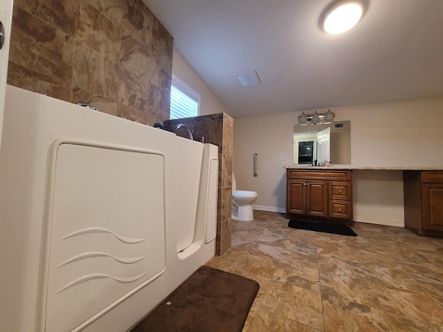 full bathroom with a walk in shower, toilet, vanity, baseboards, and washer / clothes dryer