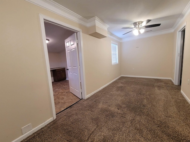 carpeted empty room with baseboards, ceiling fan, and crown molding