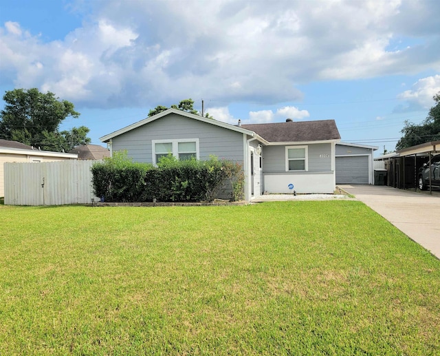 ranch-style home featuring an outbuilding, concrete driveway, a front yard, fence, and a garage