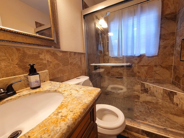 full bathroom featuring toilet, a stall shower, tile walls, and vanity