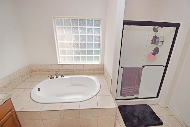 bathroom with tile patterned floors, vanity, and tiled tub