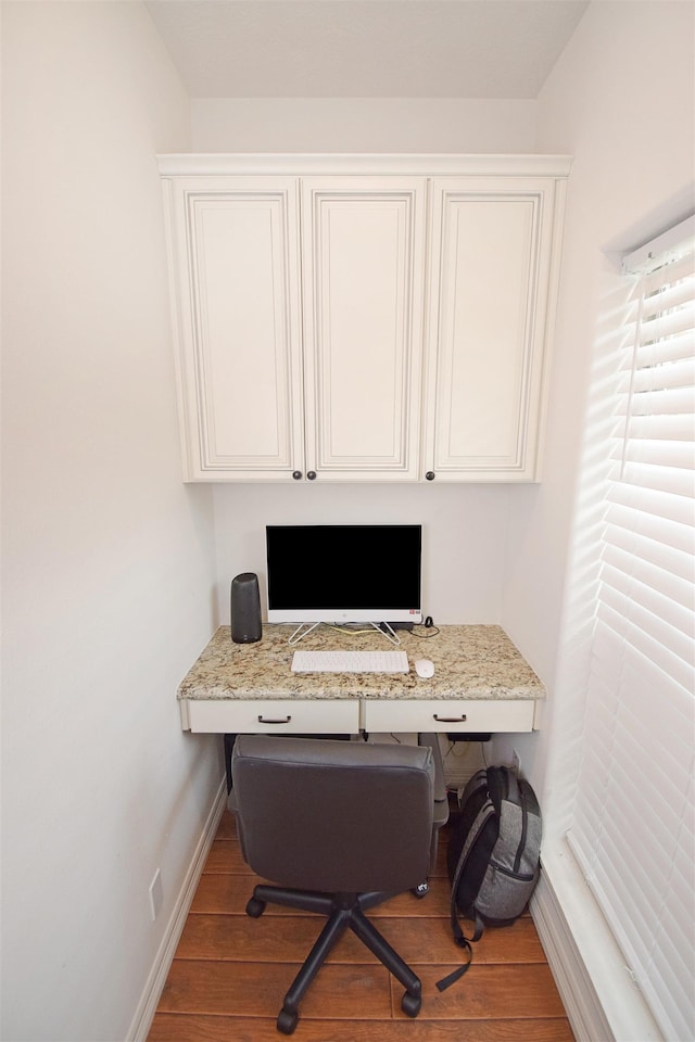 home office with hardwood / wood-style flooring and built in desk