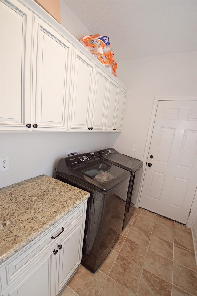 laundry area featuring cabinets and washer and clothes dryer