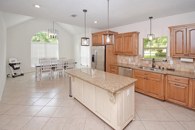 kitchen with sink, light tile patterned floors, appliances with stainless steel finishes, hanging light fixtures, and a center island