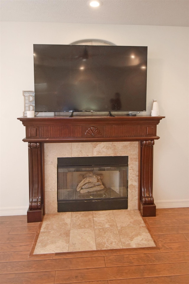 room details with wood-type flooring and a tile fireplace