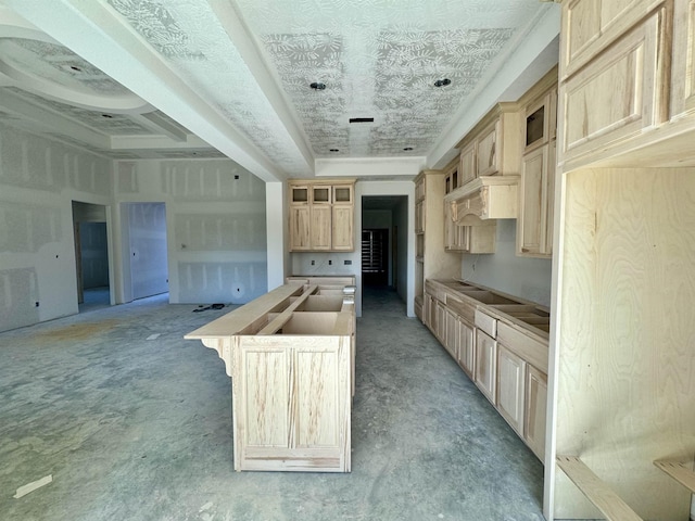 kitchen with light brown cabinets, wooden counters, premium range hood, and a tray ceiling