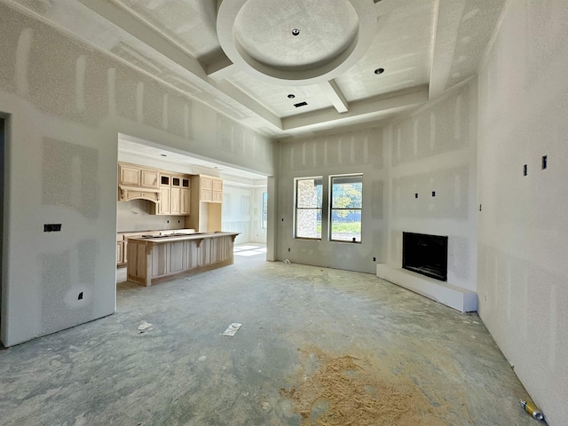 unfurnished living room featuring a towering ceiling and coffered ceiling