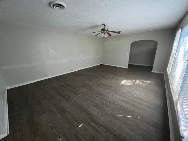 spare room with ceiling fan, dark wood-type flooring, and a textured ceiling