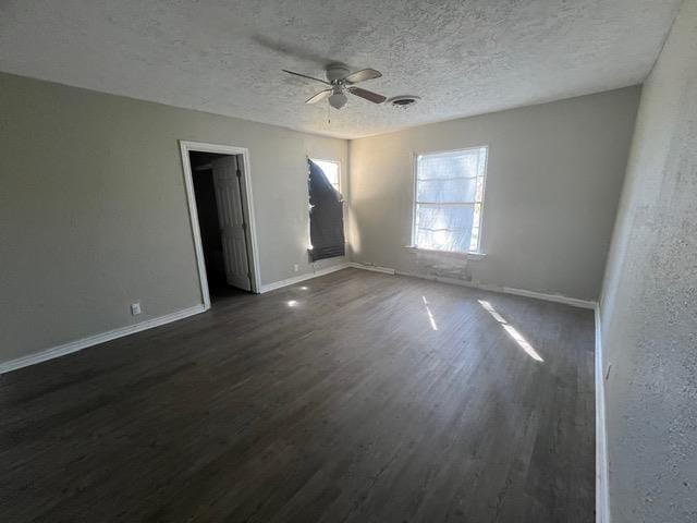 spare room featuring a textured ceiling, ceiling fan, and dark wood-type flooring