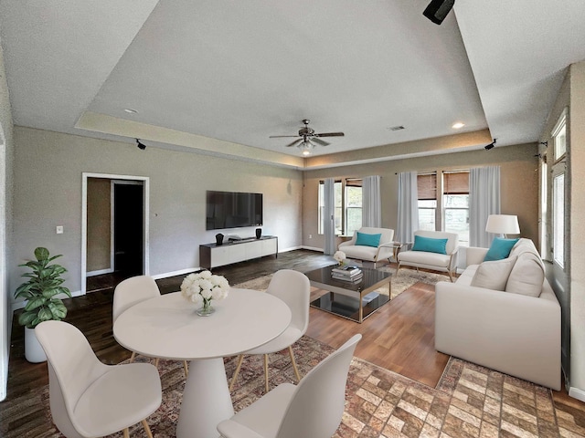 interior space with hardwood / wood-style floors, a tray ceiling, and ceiling fan