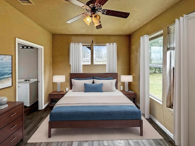 bedroom featuring multiple windows, dark hardwood / wood-style flooring, and ceiling fan