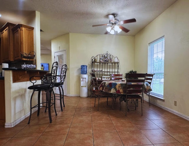 8135 Dawn Dr, Beaumont, TX 77705 - dining space featuring light tile patterned floors, ceiling fan, a textured ceiling, and baseboards