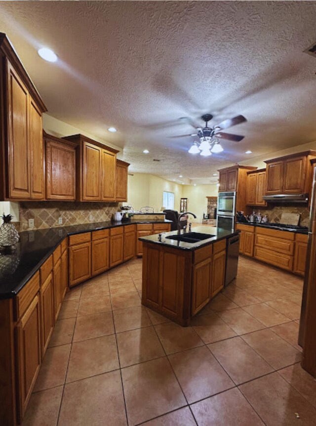 8135 Dawn Dr, Beaumont, TX 77705 - kitchen featuring a sink, light tile patterned flooring, dark countertops, recessed lighting, and a textured ceiling