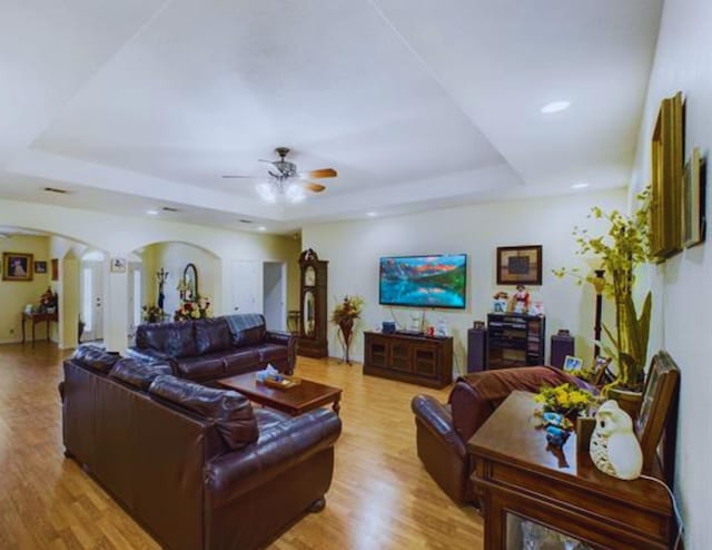 8135 Dawn Dr, Beaumont, TX 77705 - living room featuring a tray ceiling, a ceiling fan, arched walkways, wood finished floors, and recessed lighting