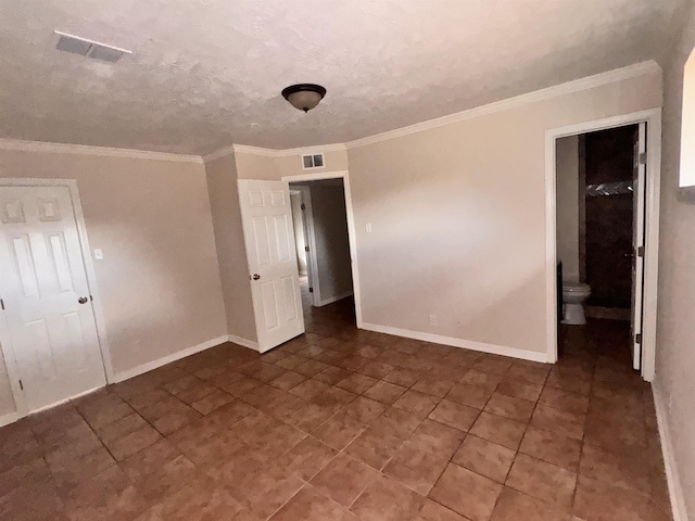 empty room with crown molding and a textured ceiling