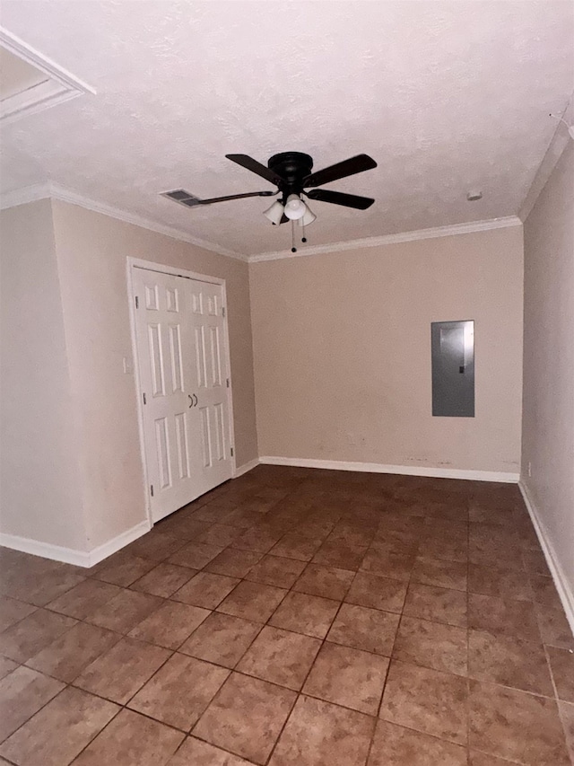 tiled spare room with electric panel, ceiling fan, a textured ceiling, and ornamental molding