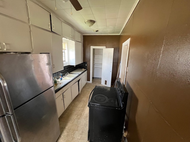 2849 12th St, Port Arthur, TX 77642 - kitchen with freestanding refrigerator, electric range, tasteful backsplash, white cabinets, and a ceiling fan
