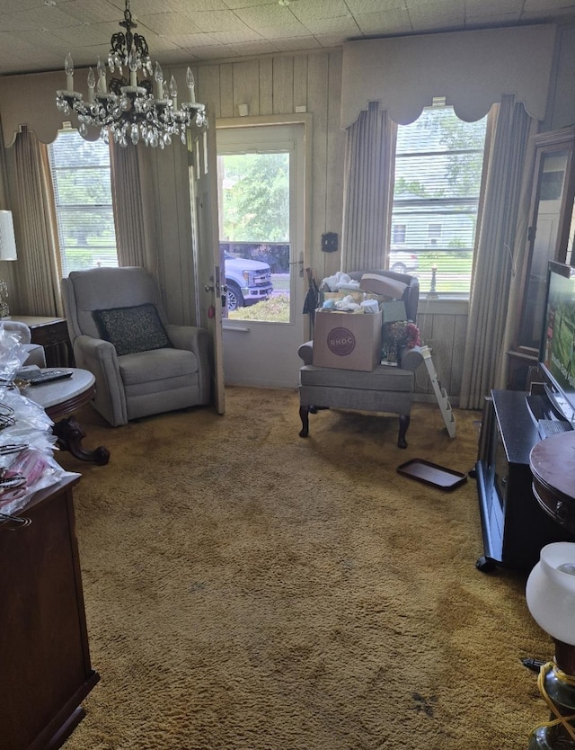 301 Morrell Blvd, Orange, TX 77630 - living room featuring a chandelier, carpet floors, healthy amount of natural light, and wooden walls