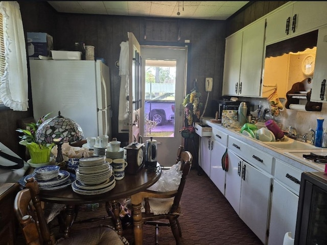 301 Morrell Blvd, Orange, TX 77630 - kitchen featuring white appliances, dark colored carpet, light countertops, white cabinetry, and a sink