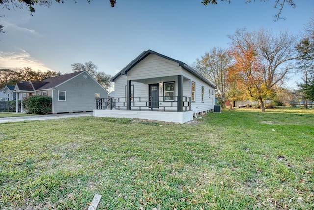 view of front of house featuring a front yard, a porch, and central AC unit