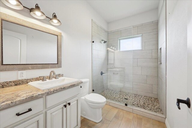 1215 Bourbon St, Bridge City, TX 77611 - bathroom with toilet, vanity, a tile shower, and wood finished floors