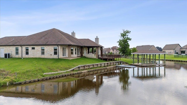 1215 Bourbon St, Bridge City, TX 77611 - back of house featuring a chimney, central AC, a water view, and a lawn