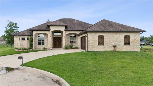 1215 Bourbon St, Bridge City, TX 77611 - french country style house with roof with shingles, a front yard, concrete driveway, a garage, and a chimney