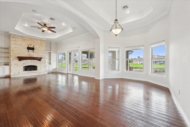 1215 Bourbon St, Bridge City, TX 77611 - unfurnished living room featuring a raised ceiling, ceiling fan, hardwood / wood-style floors, a fireplace, and ornamental molding