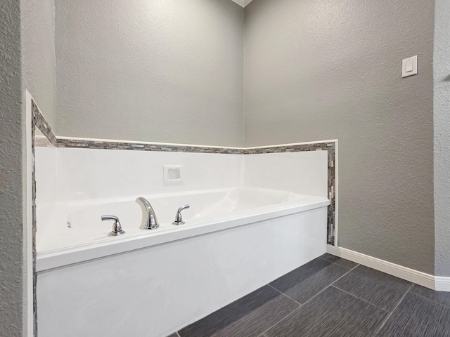 3760 Seminole Dr, Beaumont, TX 77707 - bathroom featuring a textured wall, a garden tub, and baseboards