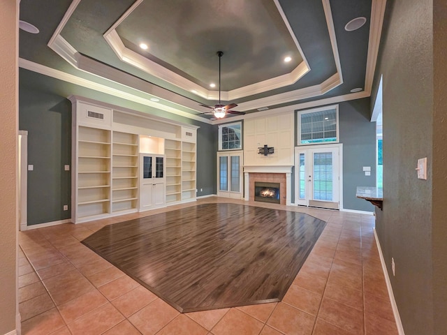 3760 Seminole Dr, Beaumont, TX 77707 - unfurnished living room featuring a tray ceiling, light tile patterned floors, crown molding, baseboards, and built in features