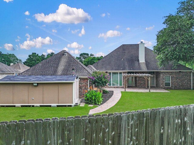 3760 Seminole Dr, Beaumont, TX 77707 - back of property featuring a shingled roof, a chimney, brick siding, and a patio area