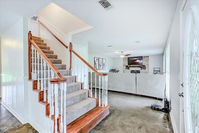 109 Twin Pines Cir, Beaumont, TX 77705 - stairway featuring a ceiling fan, a fireplace, and concrete floors