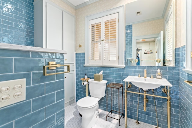 bathroom featuring tile patterned floors, sink, toilet, ornamental molding, and tile walls