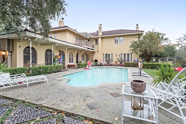 view of swimming pool featuring ceiling fan and a patio