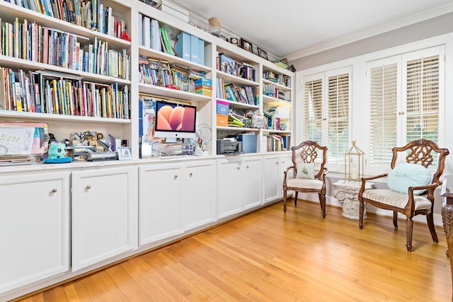 sitting room with light hardwood / wood-style flooring and crown molding