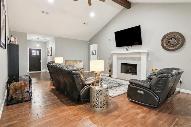 living room with ceiling fan and vaulted ceiling with beams