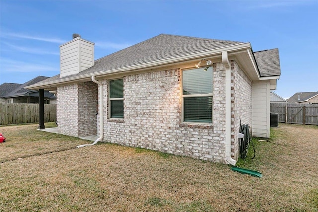 rear view of house featuring a yard and central AC unit