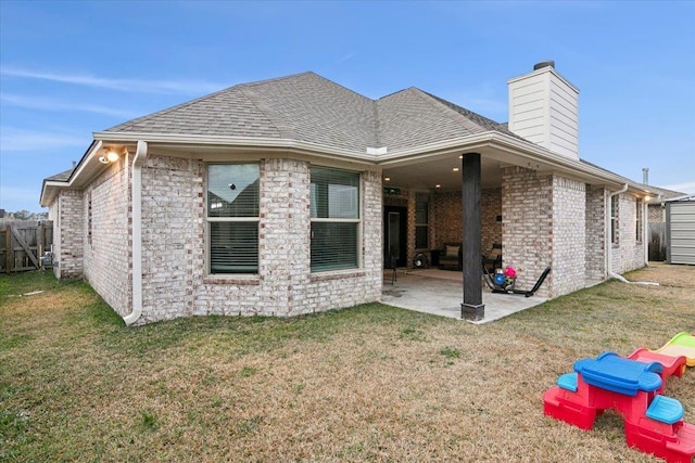 rear view of property featuring a lawn and a patio area