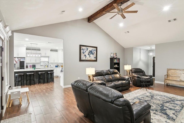 living room with ceiling fan, sink, and lofted ceiling with beams